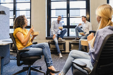 Businesswomen having lunch with coworkers in office - DIGF16695