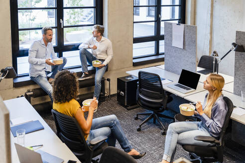 Mitarbeiter beim Essen im Coworking-Büro - DIGF16698