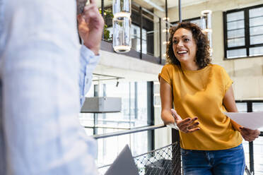 Smiling businesswoman discussing with colleague in office - DIGF16716