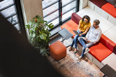 Coworkers discussing over document in office - DIGF16730