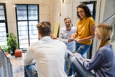 Cheerful businesswoman with colleagues in office - DIGF16739