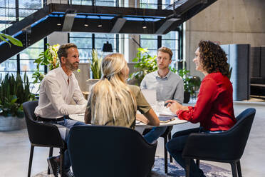 Smiling coworkers attending meeting in office - DIGF16862