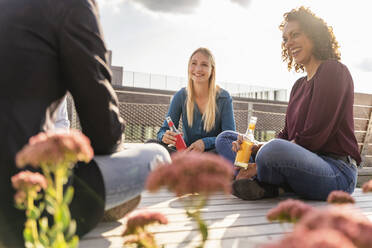 Kollegen beim Feierabendgetränk auf der Terrasse - DIGF16944