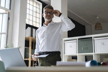 Businessman wearing eyeglasses at desk - GIOF13931