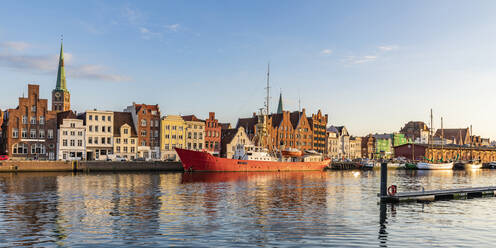 Deutschland, Schleswig-Holstein, Lübeck, Panoramablick auf die Trave mit vertäutem Schiff und historischen Stadthäusern im Hintergrund - WDF06654