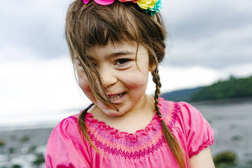 Nahaufnahme eines lächelnden jungen Mädchens am Strand - CAVF94936