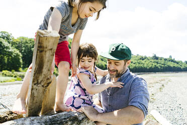 Closeup view of a father and two daughters playing together - CAVF94939