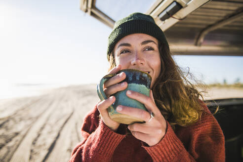 Junge Frau genießt Tasse Kaffee in den Morgen Strand Auto Camping - CAVF94961