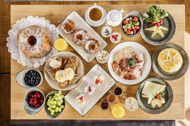 Studio shot of breakfast table filled with various desserts, fruits and vegetables - DAWF02064