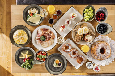 Studio shot of breakfast table filled with various desserts, fruits and vegetables - DAWF02070