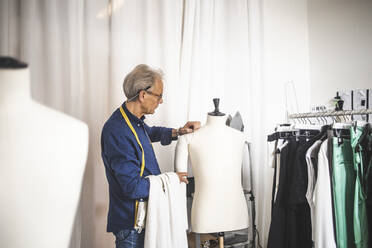 Male entrepreneur examining mannequin at boutique - MASF26446