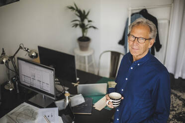 High angle view of male owner with coffee cup at workshop - MASF26469