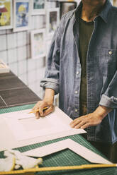 Mittelteil eines Handwerkers mit Papier und Bleistift in einem Einzelhandelsgeschäft - MASF26506