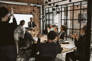 Business people applauding during meeting in board room - MASF26637