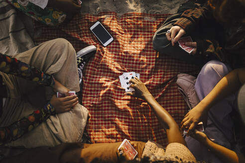 Multiracial friends playing cards at beach - MASF26681