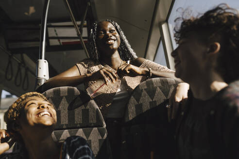 Glückliche multirassische LGBTQIA-Freunde im Bus an einem sonnigen Tag - MASF26734