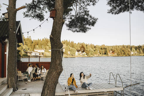 Freundinnen verbringen Freizeit am Steg am See - MASF26786