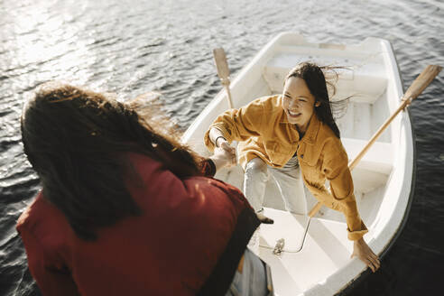 Hohe Winkel Ansicht der Frau hilft weiblichen Freund für den Ausstieg aus dem Boot - MASF26792
