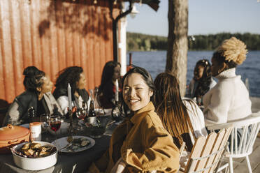 Porträt einer lächelnden Frau mit Freundinnen auf einer Party an einem sonnigen Tag - MASF26804