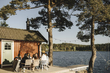 Weibliche Freunde beim Abendessen im Hinterhof an einem sonnigen Tag - MASF26809