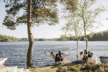 Multirassische Freundinnen genießen am Seeufer an einem sonnigen Tag - MASF26818