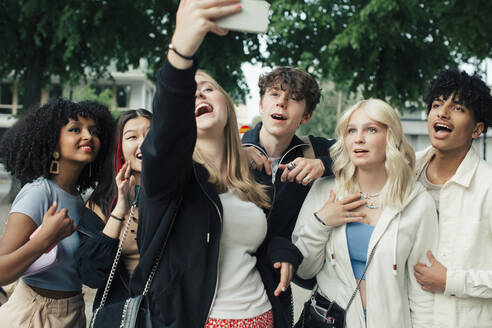 Glückliche männliche und weibliche Freunde nehmen Selfie auf Smartphone - MASF26857