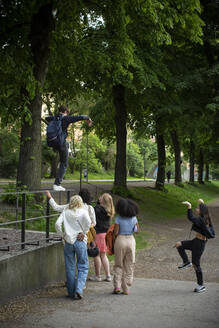 Männliche und weibliche Teenager-Freunde spielen im Park - MASF26859