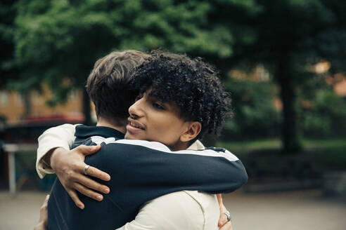 Männliche Freunde umarmen sich, während sie im Park abhängen - MASF26935