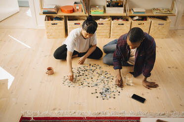 Multirassischer Mann und Freundin spielen Puzzle zu Hause - MASF27008