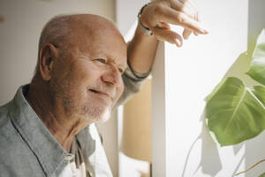 Smiling senior man day dreaming at home - MASF27018