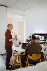 Männlicher Hacker präsentiert Geschäftsidee während eines Treffens in einem Start-up-Unternehmen - MASF27109