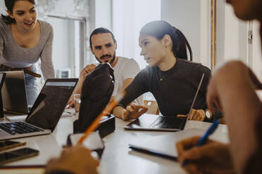 Young businesswoman discussing with colleagues in meeting at office - MASF27123