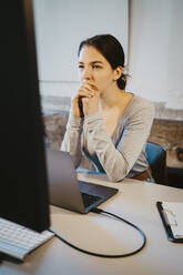 Junge Programmiererin beim Brainstorming am Computer im Büro - MASF27126