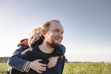 Smiling man giving piggyback ride to son - IHF00598