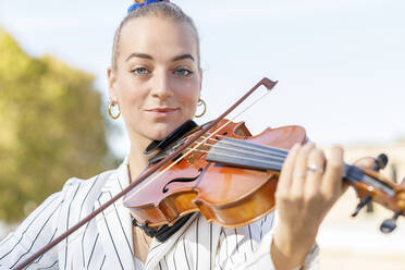 Lächelnder junger Musiker spielt Geige - IFRF01185