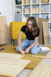 Young woman assembling piece of furniture - GIOF13976