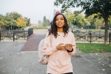 Young black woman enjoying city living outdoor using smartphone - Milan, Lombardy, Italy - browsing, ... - MEUF04674