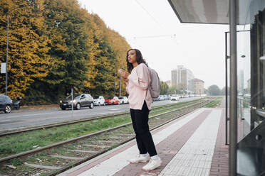 Junge Frau mit Rucksack am Bahnhof - MEUF04687