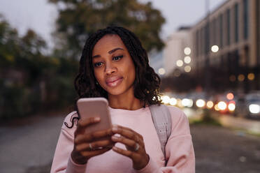 Woman using mobile phone at sunset - MEUF04695