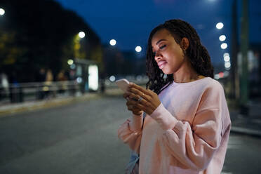 Young woman using smart phone at night - MEUF04702