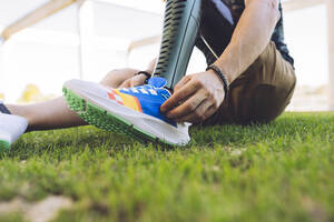 Mann mit amputiertem Bein trägt Schuhe im Gras - JCCMF04370