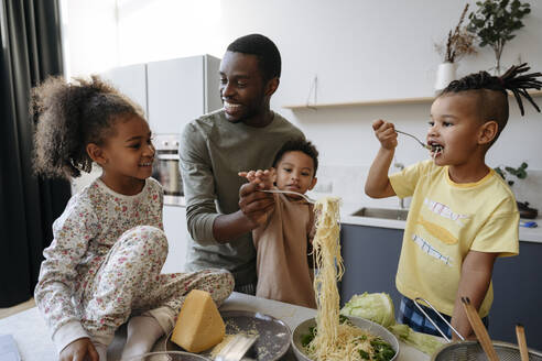 Familie genießt Spaghetti in der Küche - VYF00633