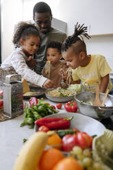 Familie genießt Spaghetti in der Küche zu Hause - VYF00636