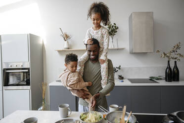 Lächelnder Vater mit Tochter und Sohn in der Küche - VYF00649