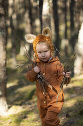 Cute girl holding wooden sticks in forest - SSGF00189