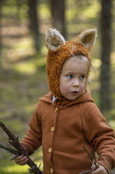 Cute girl wearing hat holding sticks in forest - SSGF00208