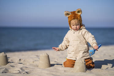 Mädchen baut Sandburgen am Strand an einem sonnigen Tag - SSGF00209