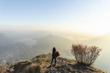 Hiker woman on mountain peakc at sunset, Orobie Alps, Lecco, Italy - MCVF00934