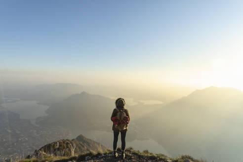 Wanderin betrachtet die Landschaft vom Berggipfel aus, Lecco, Italien - MCVF00935