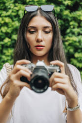 Frau mit Sonnenbrille, die durch eine Digitalkamera fotografiert - JRVF02025